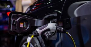 A close-up of an electric car being charged, with a charging cable